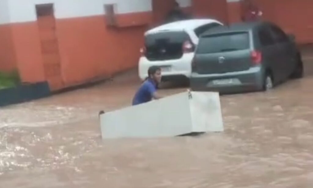 Homem Navega em Avenida Alagada Usando Geladeira Após Chuva em Manaus